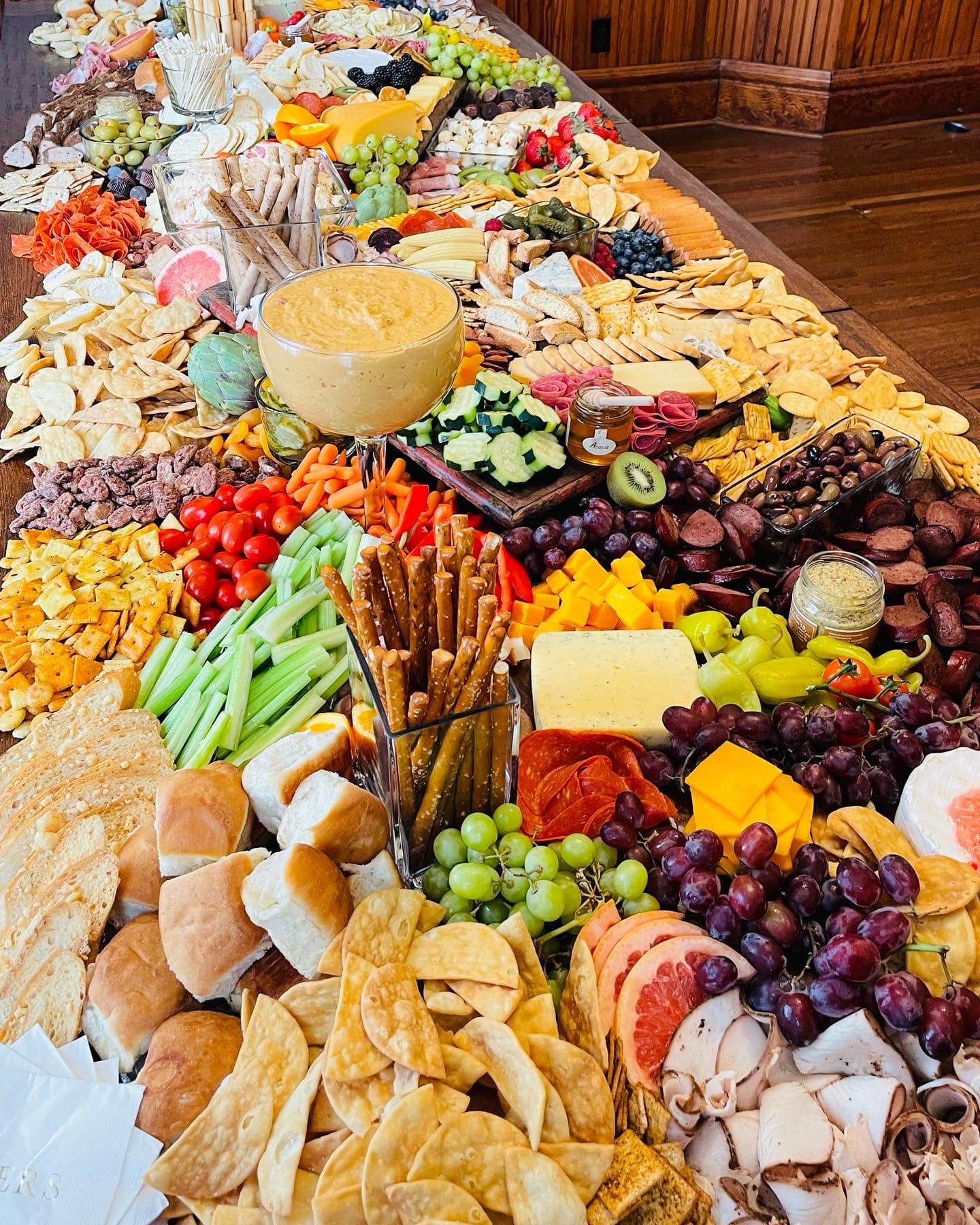 charcuterie board full of meat, crackers, cheese, fruit, nuts, and vegetables